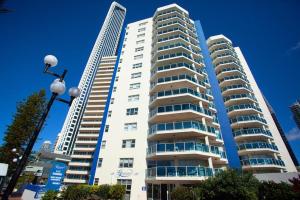 two tall white buildings next to each other at Grosvenor Beachfront Apartments Surfers Paradise in Gold Coast