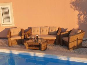 a patio with a couch and chairs next to a pool at Villa M in Crikvenica