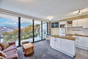 a kitchen and living room with a large window at Snow Ski Apartments 26 in Falls Creek