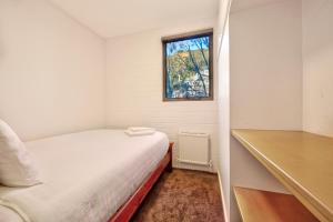 a small bedroom with a bed and a window at Snow Ski Apartments 25 in Falls Creek