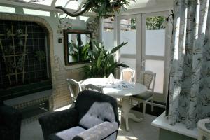 d'une terrasse avec une table, des chaises et un miroir. dans l'établissement The Butterfly Luxe appartement met private Parking, à Zandvoort