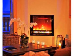 a living room with a fireplace and a table with flowers at Lavish Holiday Home in H r mence with Balcony in Hérémence