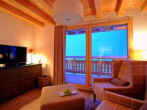 uma sala de estar com um sofá e uma televisão em Lavish Holiday Home in H r mence with Balcony em Hérémence