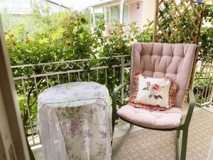 チンクアレにあるB&B Due Passi dal Mareのピンクの椅子(枕はスツールの横に置かれています)