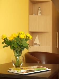 eine Vase gelber Blumen auf einem Tisch in der Unterkunft Aparthotel Strandhus in Ahlbeck