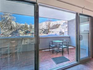 a sliding glass door with a table and chairs on a patio at Snow Ski Apartments 36 in Falls Creek