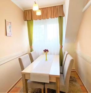 a dining room table with a white tablecloth at Apartman Siesta Bük in Bük