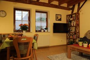 a living room with a dining room table and a tv at Ferienhof Seeber in Weikersheim