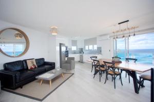a living room with a black couch and a table at Grosvenor Beachfront Apartments Surfers Paradise in Gold Coast