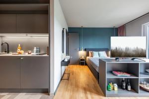 布伦瑞克ipartment Braunschweig的一间带床和厨房的小卧室