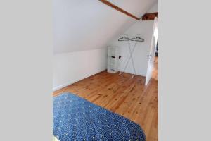 Zimmer mit einem blauen Ottomanen auf einem Holzboden in der Unterkunft Appartement moderne et lumineux in Brive-la-Gaillarde