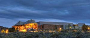 a building with a tent in the middle of a field at Sanbona Wildlife Reserve in Barrydale