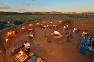 an overhead view of a patio with people sitting around tables and fires at Sanbona Wildlife Reserve in Barrydale