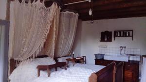 a bedroom with a canopy bed with curtains at Le Porteau Enchanteur in Sarzay