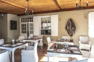 a dining room with tables and white chairs at Sanbona Wildlife Reserve in Barrydale