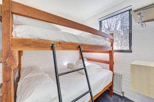 two bunk beds in a small room with a window at Snow Ski Apartments 22 in Falls Creek