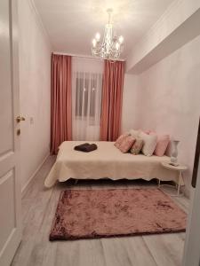 um quarto com uma cama grande e um lustre em Apartament Larysse em Oradea