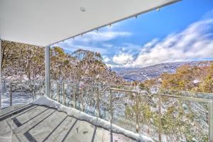 a view from the balcony of a house with snow covered trees at Snow Ski Apartments 22 in Falls Creek