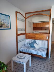 a small bedroom with a bed and a table at La Gavine studio vue mer in Hyères