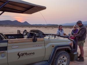 a group of people standing next to a jeep in the desert at Sanbona Wildlife Reserve in Barrydale