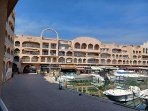 a large building with boats in a marina at La Gavine studio vue mer in Hyères