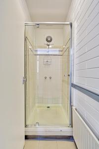 a shower with a glass door in a bathroom at Snow Ski Apartments 18 in Falls Creek