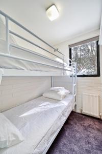 a bedroom with two bunk beds and a window at Snow Ski Apartments 18 in Falls Creek