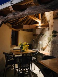 una mesa y sillas en una habitación con una pared de piedra en Au Fil du Temps en Mallièvre