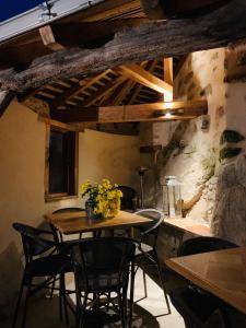 a table and chairs in a room with a stone wall at Au Fil du Temps in Mallièvre