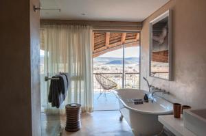 a bathroom with a tub and a window with a view at Sanbona Wildlife Reserve in Barrydale