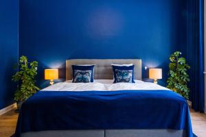 a blue bedroom with a large bed with blue walls at 'Gem Suites Luxury Holiday Apartments in Augustenborg