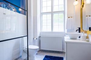 a bathroom with a toilet and a sink at 'Gem Suites Luxury Holiday Apartments in Augustenborg