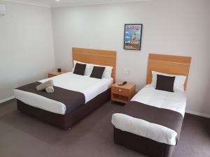 two beds in a hotel room with two beds sidx sidx sidx at Golden Reef Motor Inn in Bendigo +22 photos