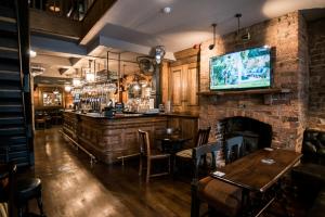a bar with a fireplace and a tv on a brick wall at Lower Turks Head in Manchester