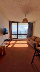 a living room with a couch and a large window at Studio 05 Saint Honoré 1500, Vue montagne et lac, 2 personnes, Série Anthracite Netflix in Saint-Honoré
