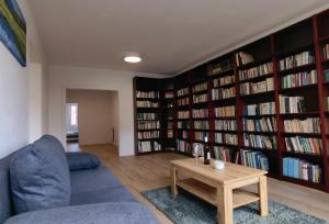 een woonkamer met boekenplanken gevuld met boeken bij Apartmán Športová in Trnava