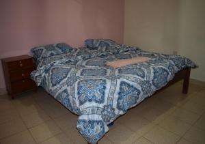 
an unmade bed in a room with a wooden floor at Mamba Village Kisumu in Kisumu
