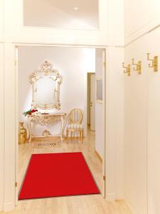 een kamer met een rood tapijt en een tafel met een spiegel bij Kaiserin Sisi in Wenen
