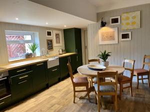 a kitchen and dining room with a table and chairs at Ginger Peanut in Bampton
