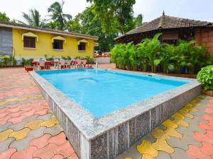 a swimming pool in front of a house at YoYoGoa Cottages in Vagator
