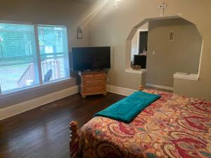 a bedroom with a bed and a flat screen tv at Magnificent Place-Moreland in Atlanta