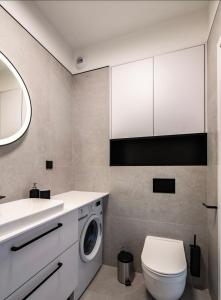 a bathroom with a washing machine and a sink at Apartament 117 - Rezydencja Niechorze in Niechorze