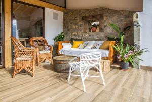 un patio con sofá, sillas y mesa en El Mirador de Armaño, en Armaño
