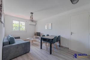 een woonkamer met een bank en een tafel bij Le coin des agrumes Jardin Proche Centre Ville in Perpignan