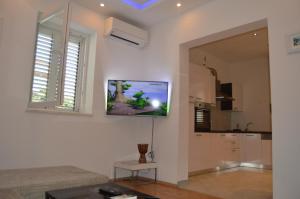 sala de estar con TV de pantalla plana en la pared en Lipa Mare, en Solin