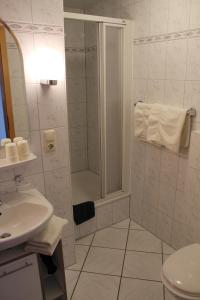 ein Bad mit einer Dusche und einem Waschbecken in der Unterkunft Ferienwohnungen Peters in Neuharlingersiel
