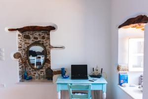 Cette chambre dispose d'une table et d'un ordinateur portable. dans l'établissement Blue & White: An Absolute Aegean dream house, à Galini