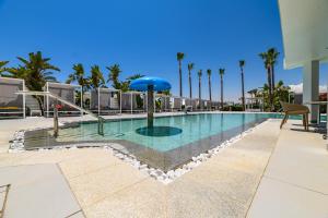 a swimming pool in a resort with palm trees at Tasia Maris Sands (Adults Only) in Ayia Napa