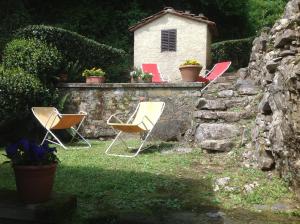 un grupo de sillas sentadas sobre una pared de piedra en Villa Morante, en Borgo a Mozzano