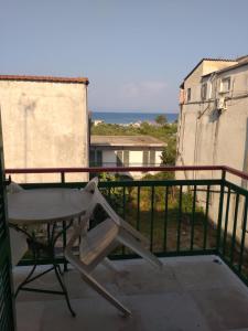 een stoel op een balkon met uitzicht op de oceaan bij Jimmy's Apartments in Moraitika